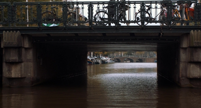 Wide shot frame from The Fault in Our Stars — walking, bicycle, water