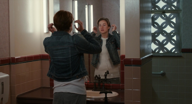 Wide shot frame from The Fault in Our Stars — standing, mirror, hand