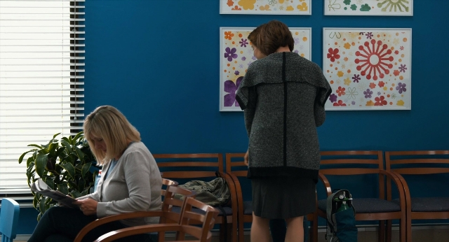 Wide shot frame from The Fault in Our Stars — sitting, book, standing
