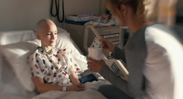 Wide shot frame from The Fault in Our Stars — sitting, bed, bottle