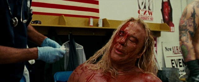 Wide shot frame from The Wrestler — room, uniform, face