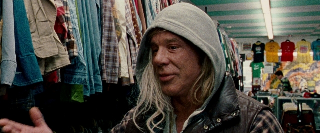 Wide shot frame from The Wrestler — standing, jacket, face