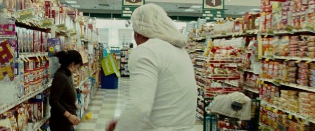 Wide shot frame from The Wrestler — standing, person, convenience store