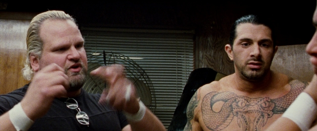 Medium shot frame from The Wrestler — room, shirt, beard