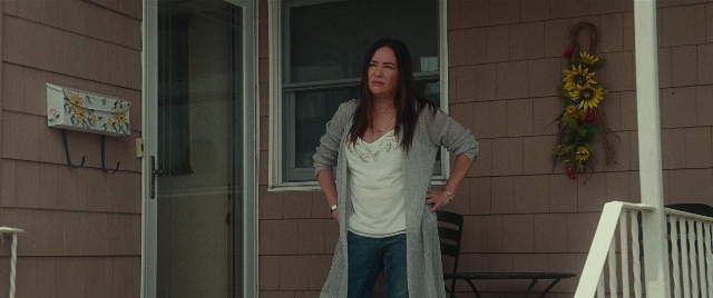 Wide shot frame from The King of Staten Island — standing, door, house