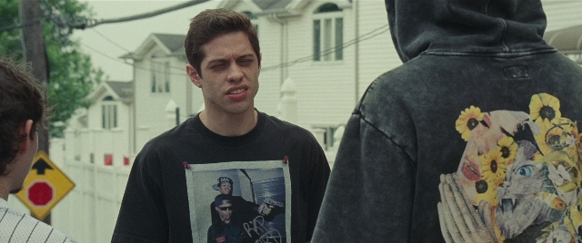 Wide shot frame from The King of Staten Island — standing, street, shirt