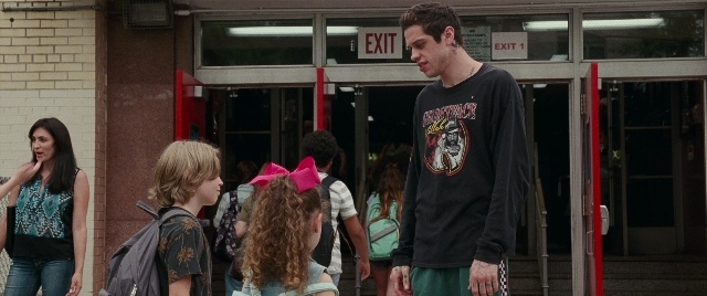 Wide shot frame from The King of Staten Island — standing, dialogue, shirt