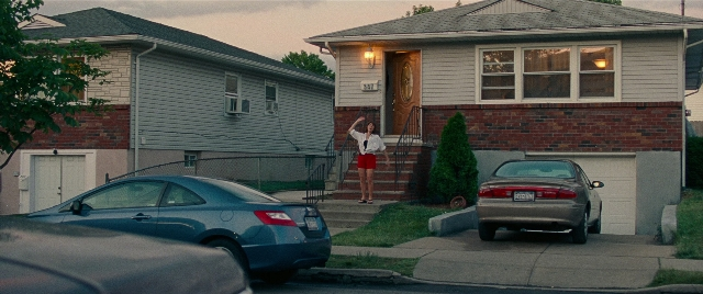 Wide shot frame from The King of Staten Island — standing, door, car