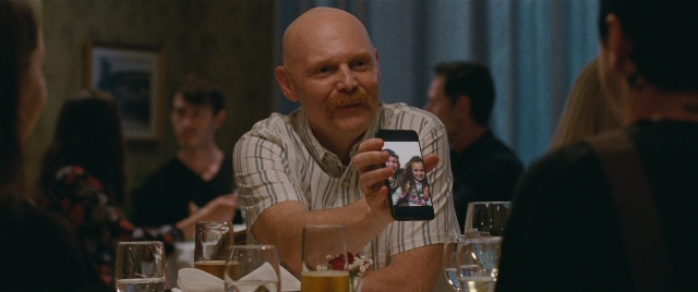 Wide shot frame from The King of Staten Island — sitting, table, phone