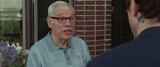 Wide shot frame from The King of Staten Island — standing, dialogue, shirt