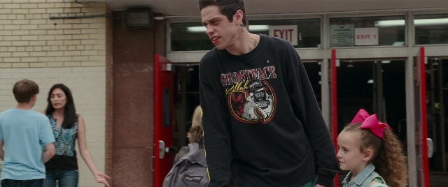 Wide shot frame from The King of Staten Island — standing, door, face