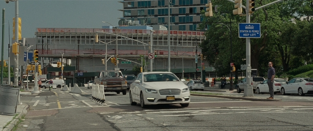 Wide shot frame from The King of Staten Island — walking, street, car