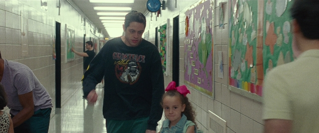 Wide shot frame from The King of Staten Island — walking, hand, person