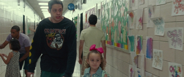 Wide shot frame from The King of Staten Island — walking, dress, face