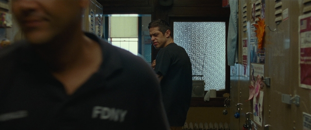 Wide shot frame from The King of Staten Island — standing, room, shirt