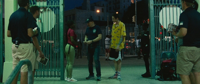Wide shot frame from The King of Staten Island — standing, dialogue, street