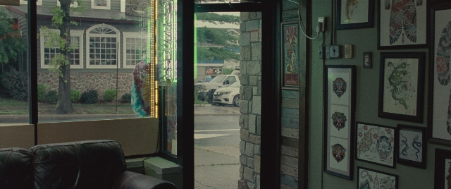 Wide shot frame from The King of Staten Island — room, door, street