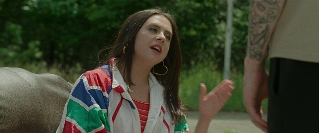Wide shot frame from The King of Staten Island — standing, hand, face