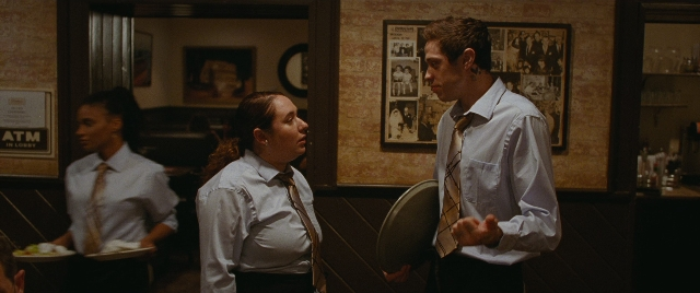 Wide shot frame from The King of Staten Island — room, dialogue, suit