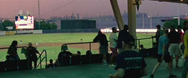 Wide shot frame from The King of Staten Island — sitting, standing, person