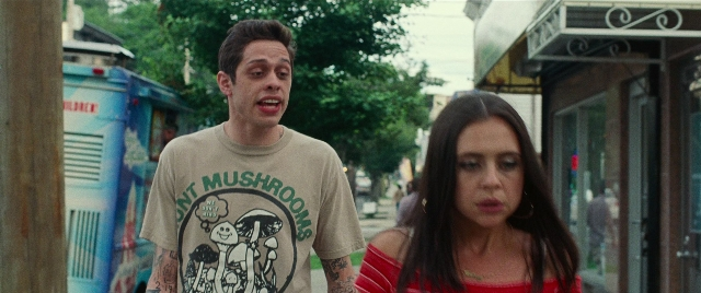 Wide shot frame from The King of Staten Island — walking, street, food