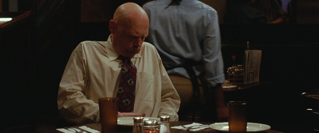 Wide shot frame from The King of Staten Island — sitting, standing, plate