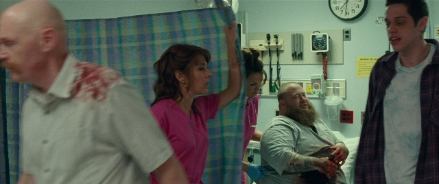 Wide shot frame from The King of Staten Island — standing, room, bed