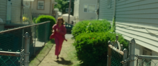 Wide shot frame from The King of Staten Island — walking, street, house