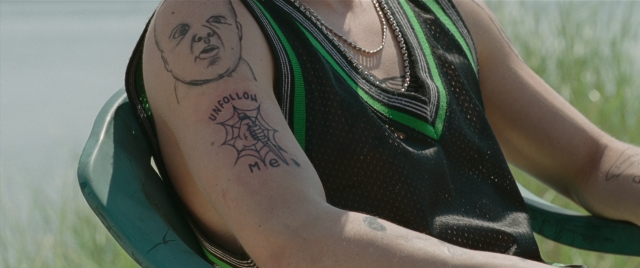 Wide shot frame from The King of Staten Island — sitting, chair, face