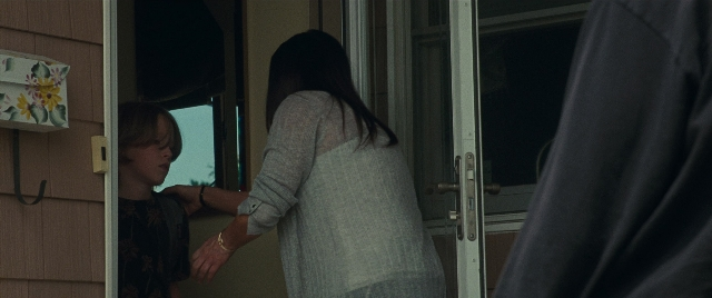 Wide shot frame from The King of Staten Island — standing, dialogue, door