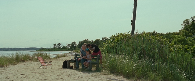 Wide shot frame from The King of Staten Island — sitting, water, chair