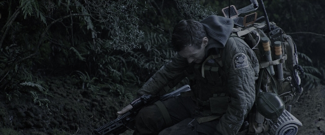 Wide shot frame from Alien: Covenant — hand, gun, forest