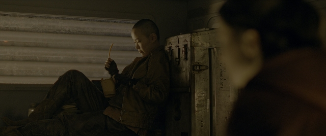 Wide shot frame from Alien: Romulus — sitting, room, door