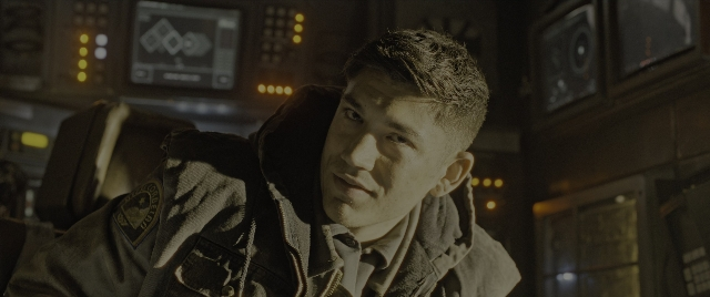 Wide shot frame from Alien: Romulus — sitting, room, face