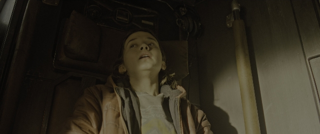 Wide shot frame from Alien: Romulus — sitting, room, door