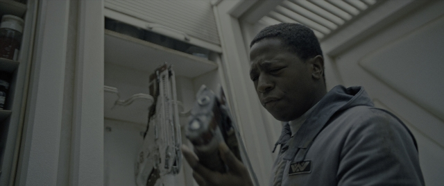 Wide shot frame from Alien: Romulus — standing, room, hand