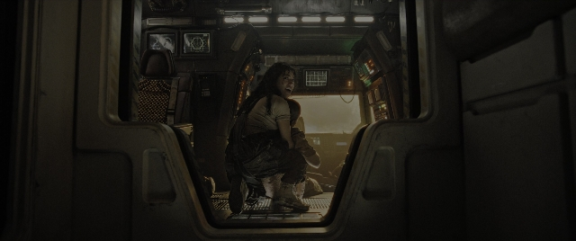 Wide shot frame from Alien: Romulus — sitting, gun, boat