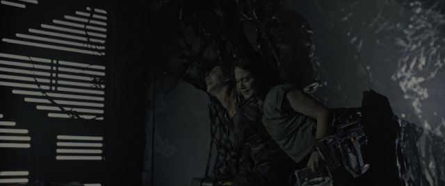 Wide shot frame from Alien: Romulus — standing, room, gun