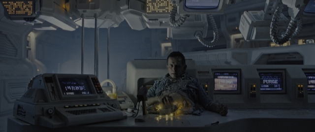 Wide shot frame from Alien: Romulus — sitting, suit, face