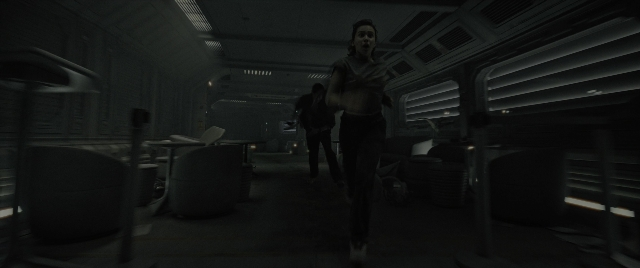 Wide shot frame from Alien: Romulus — standing, room, gun