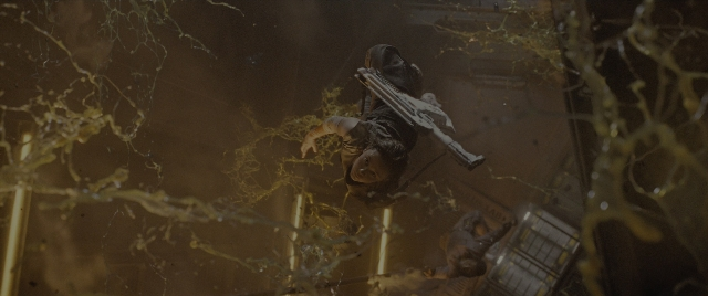 Wide shot frame from Alien: Romulus — hand, gun, person