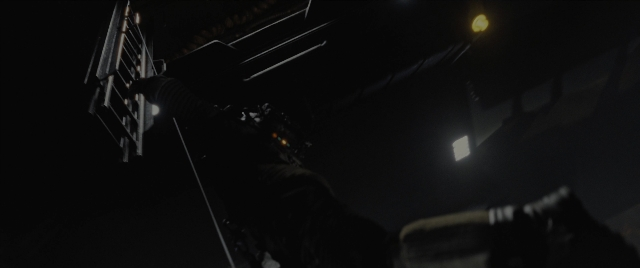 Wide shot frame from Alien: Romulus — street, hat, night