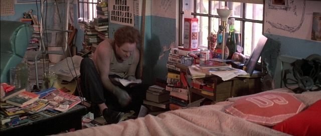 Wide shot frame from The Adventures of Buckaroo Banzai Across the 8th Dimension — sitting, book, room