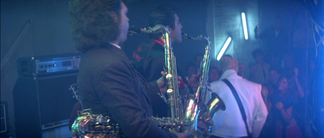 Close-up frame from The Adventures of Buckaroo Banzai Across the 8th Dimension — suit, shirt, hair