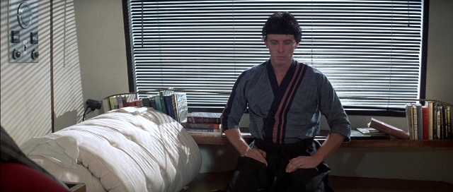 Wide shot frame from The Adventures of Buckaroo Banzai Across the 8th Dimension — sitting, book, room