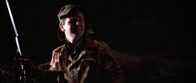 Frame from The Adventures of Buckaroo Banzai Across the 8th Dimension — standing, room, hat