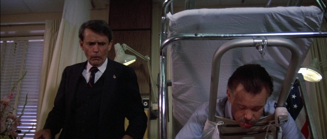 Wide shot frame from The Adventures of Buckaroo Banzai Across the 8th Dimension — standing, bed, suit