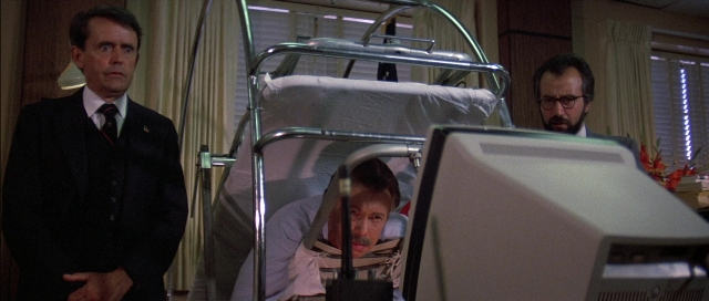 Wide shot frame from The Adventures of Buckaroo Banzai Across the 8th Dimension — standing, room, bed