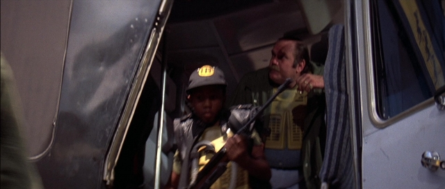 Wide shot frame from The Adventures of Buckaroo Banzai Across the 8th Dimension — standing, door, hat