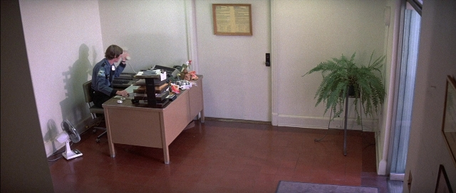 Frame from The Adventures of Buckaroo Banzai Across the 8th Dimension — sitting, desk, phone